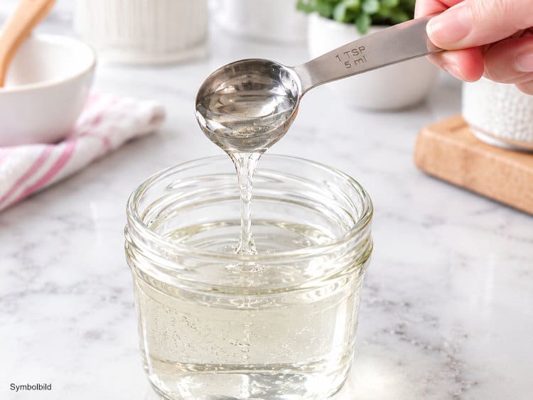 Glukosesirup wird mit einem Messlöffel abgemessen